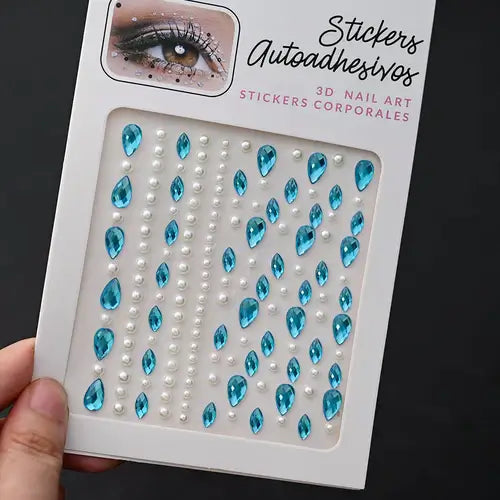 Hand holding blue tear-shaped and pearl nail art stickers for creative designs.