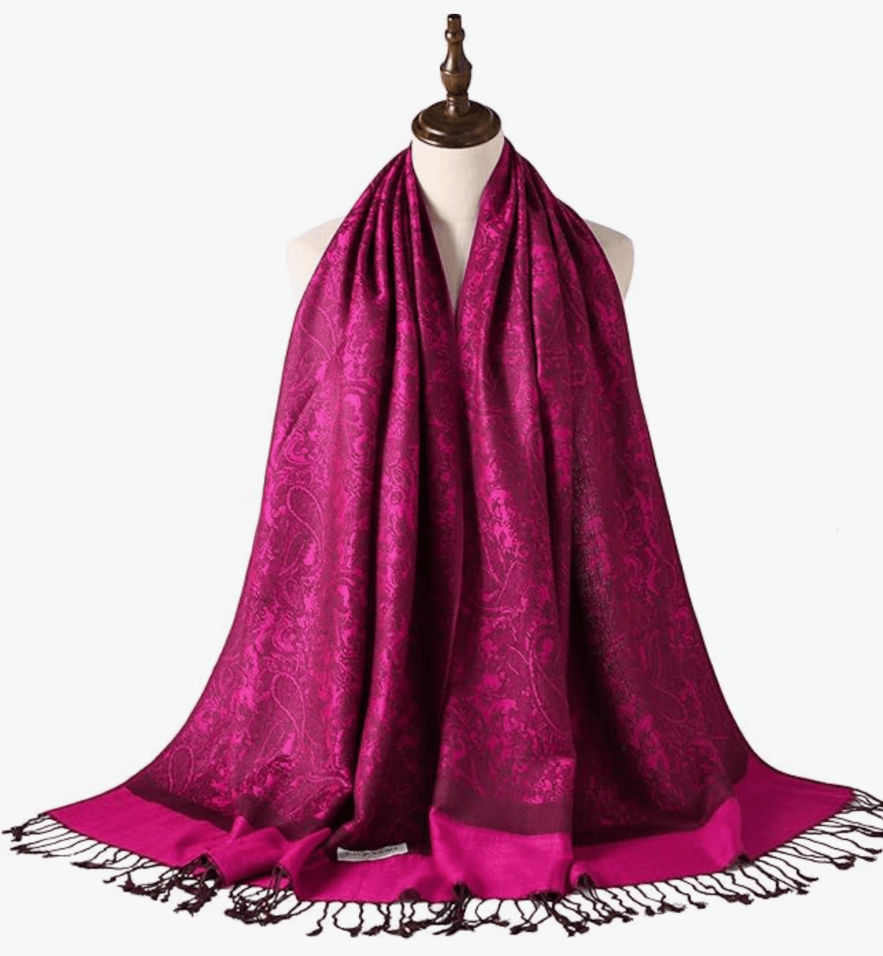 Elegant magenta pashmina shawl draped on a mannequin, featuring intricate patterns and fringed edges.