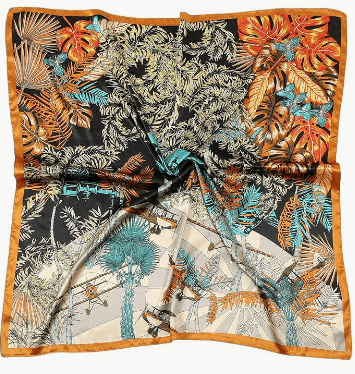 Colorful Luna Satin Headscarf featuring tropical leaves and designs in vibrant shades of orange and teal.