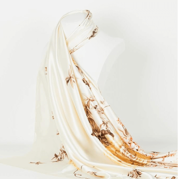 Elegant Veloura Satin Headscarf draped on a mannequin, featuring floral patterns and a soft, glossy texture.