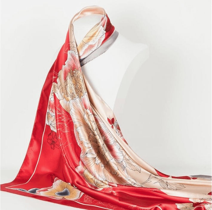 Veloura Satin Headscarf in vibrant red with floral patterns, displaying its silky texture and elegant design on a mannequin.