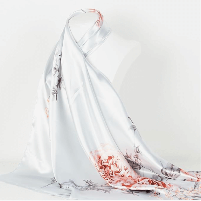 Veloura Satin Headscarf featuring floral patterns, elegantly draped on a mannequin.