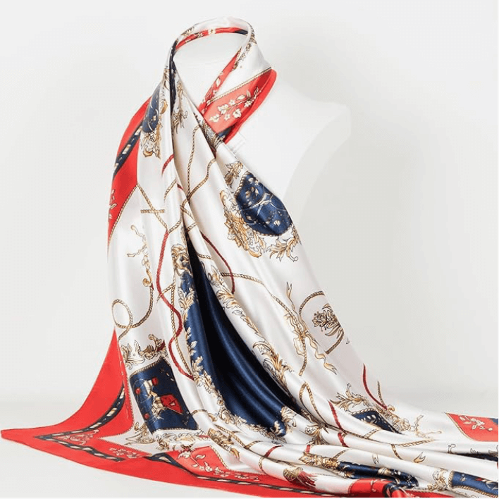 Elegant Veloura Satin Headscarf featuring a luxurious print in red, navy, and gold, perfect for versatile styling options.