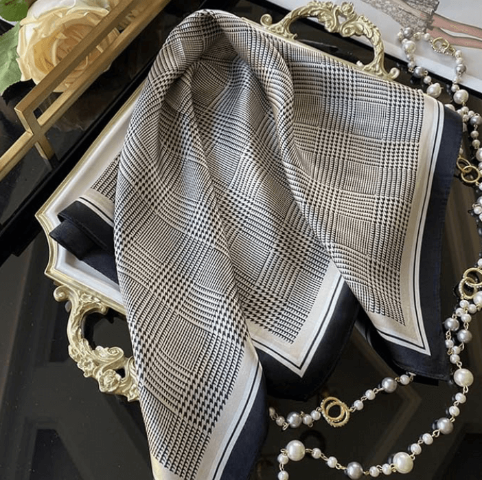 Vintage Luxe Satin Scarf with a checkered pattern on a decorative tray, perfect for stylish accessory layering.