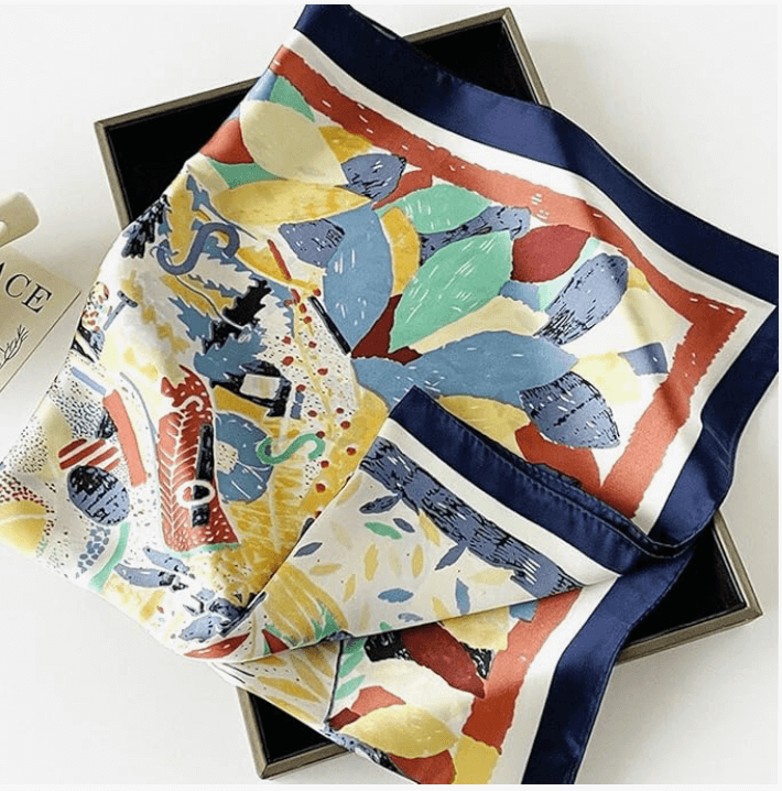 Colorful Vintage Luxe Satin Scarf displayed elegantly in a box, showcasing its vibrant patterns and luxurious texture.